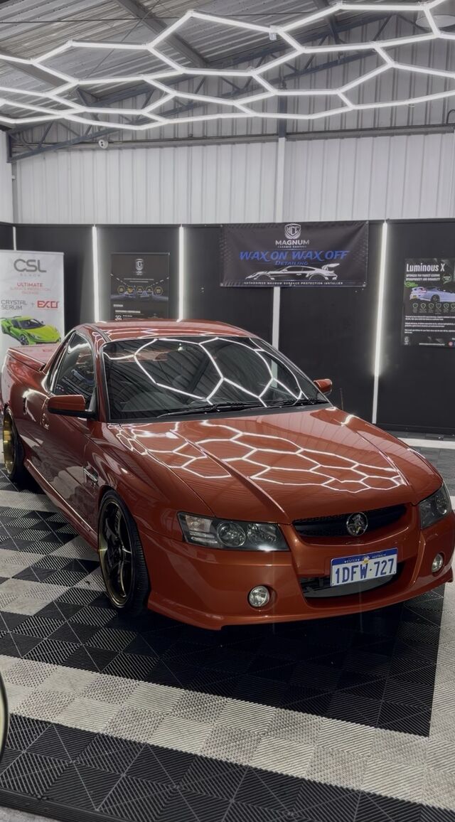Copper-orange performance ute finished in the Rockingham workshop, the hexagon lights reflected cleanly across the bonnet