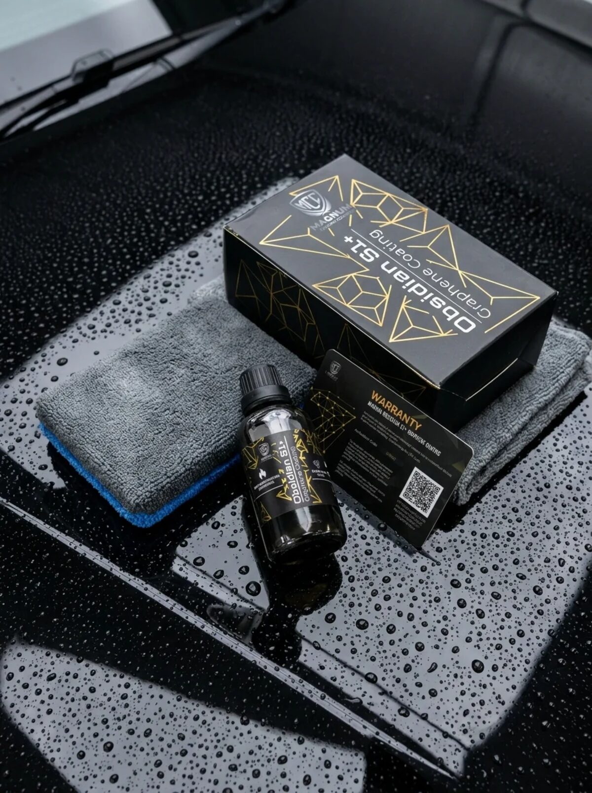 Magnum Obsidian S1+ graphene ceramic coating kit resting on a freshly coated, water-beaded panel